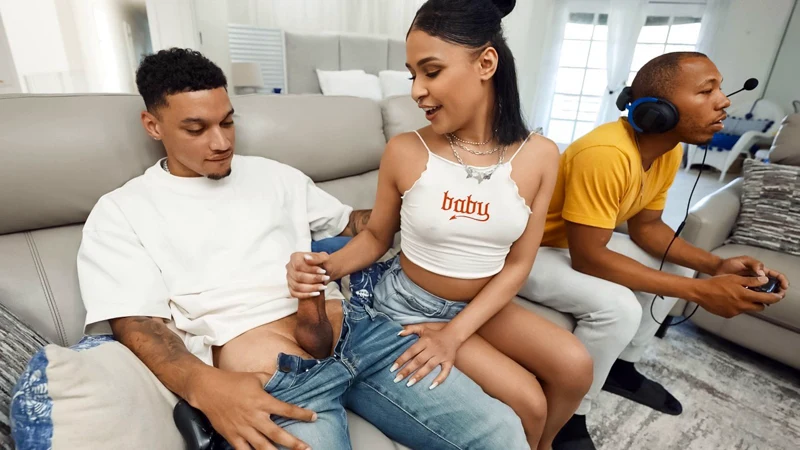While the boyfriend is busy playing with the joystick, a bored girlfriend is fiddling with his friend's joystick